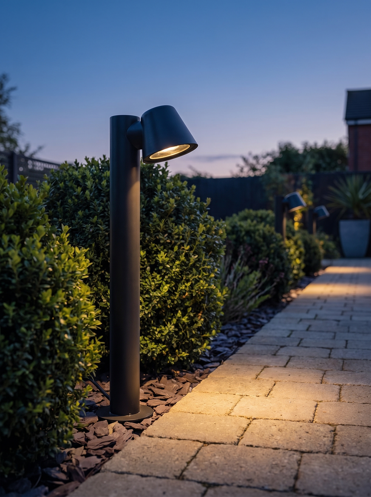 Sentry mast path light beside a stone paved garden path