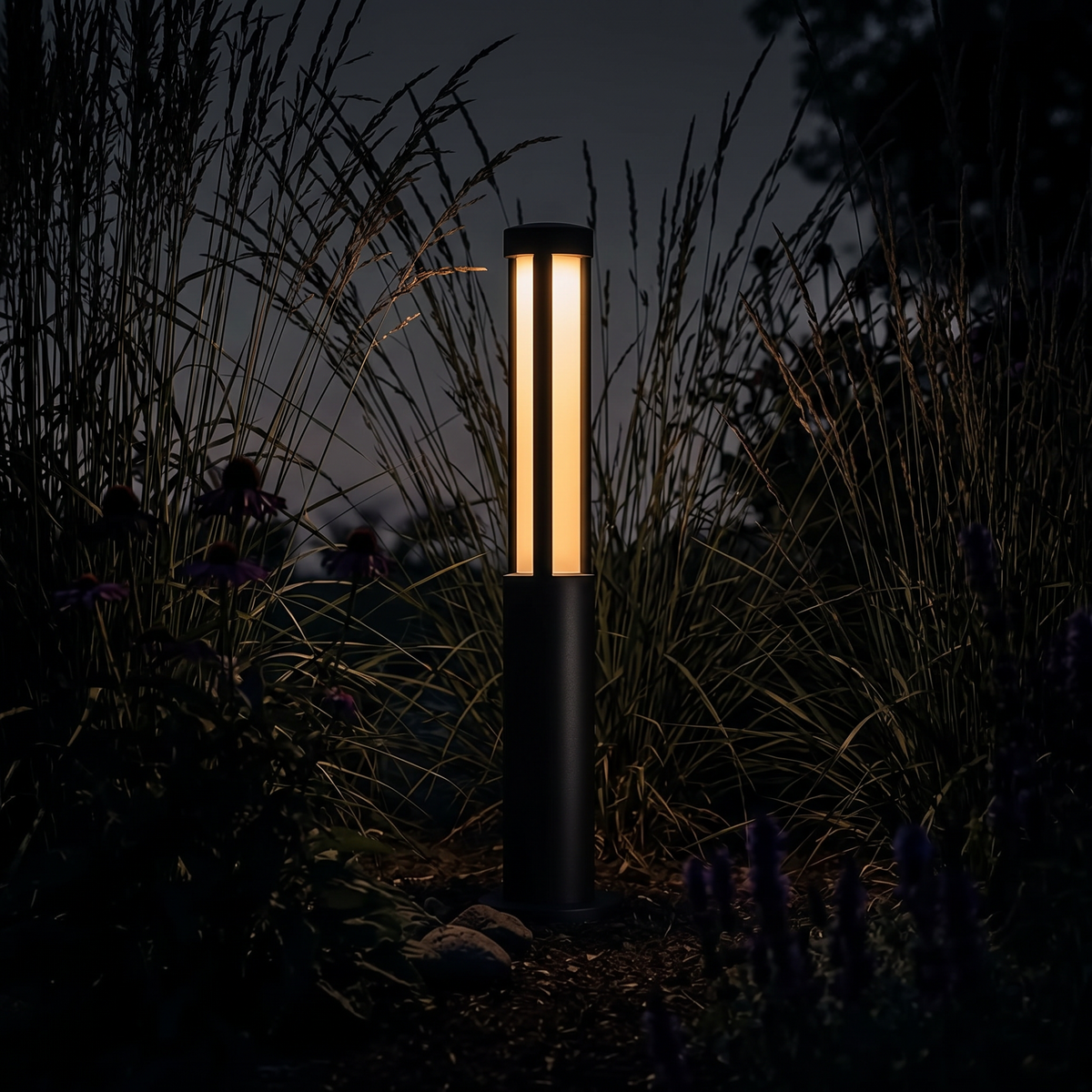 Lumira bollard light lighting a dark garden at night