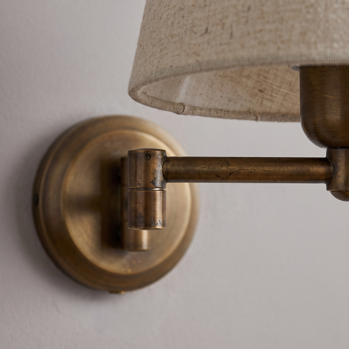 Close detail of the Marlow bronze arm joint and linen shade