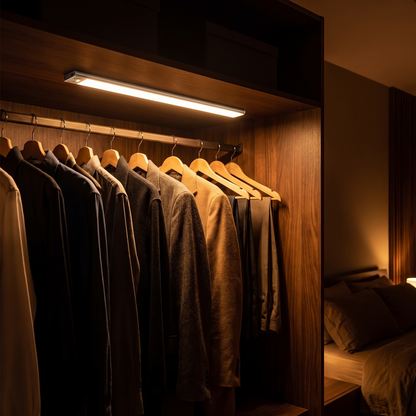 Halden light bar glowing inside a dark walnut wardrobe at night