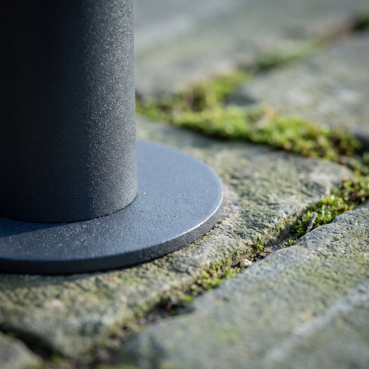 Close detail of the Sentry base plate on weathered stone paving